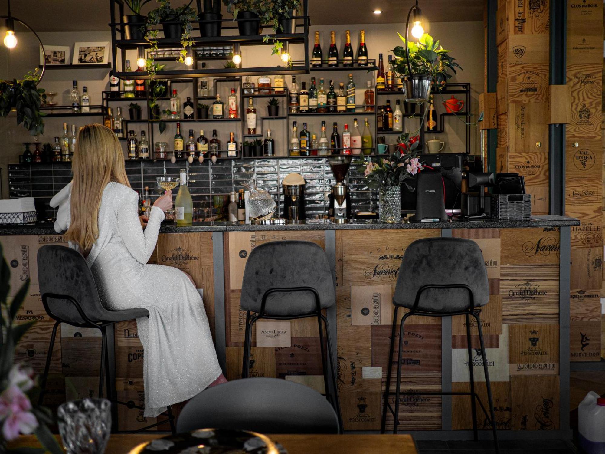 Willa Port オストルダ エクステリア 写真 A woman sitting at a bar